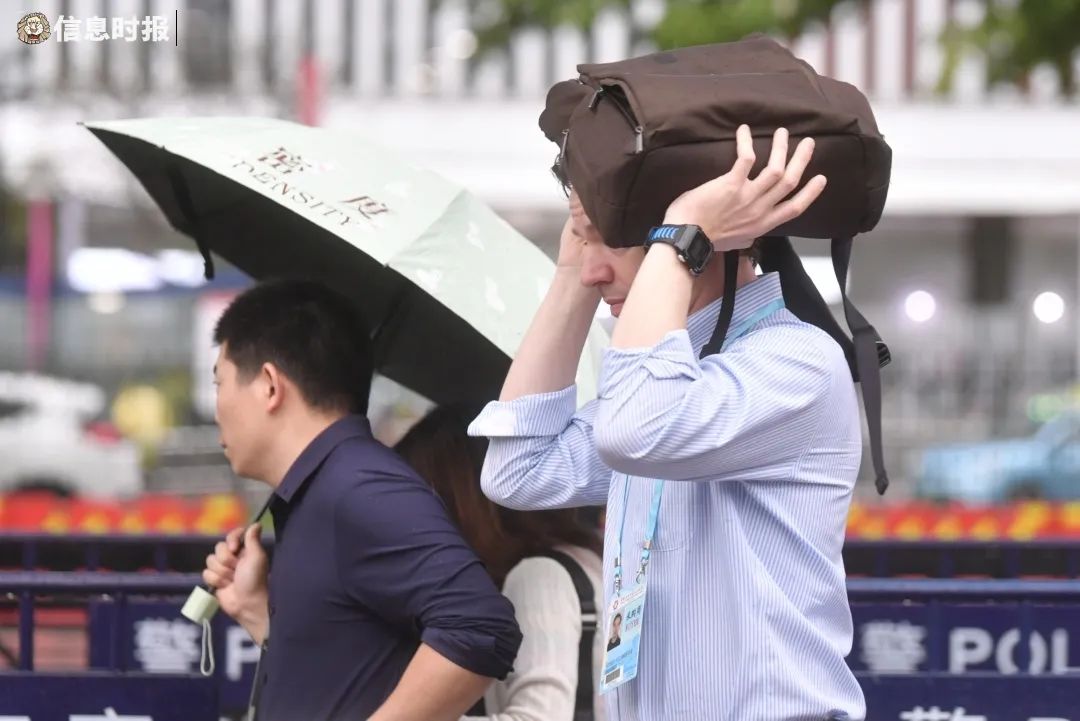 近日,广州雷雨频繁,图为4月19日琶洲地铁站附近,外商用书包挡雨.