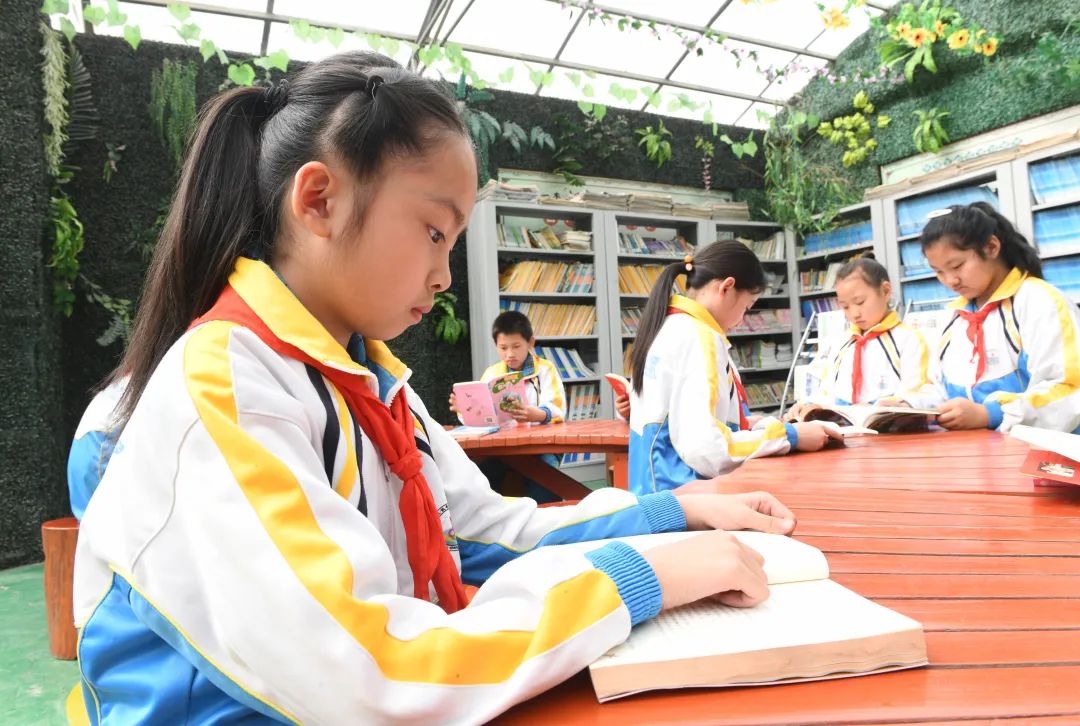 河北省石家庄新乐市东长寿学校的小学生在校园内"悦读树"下读书.