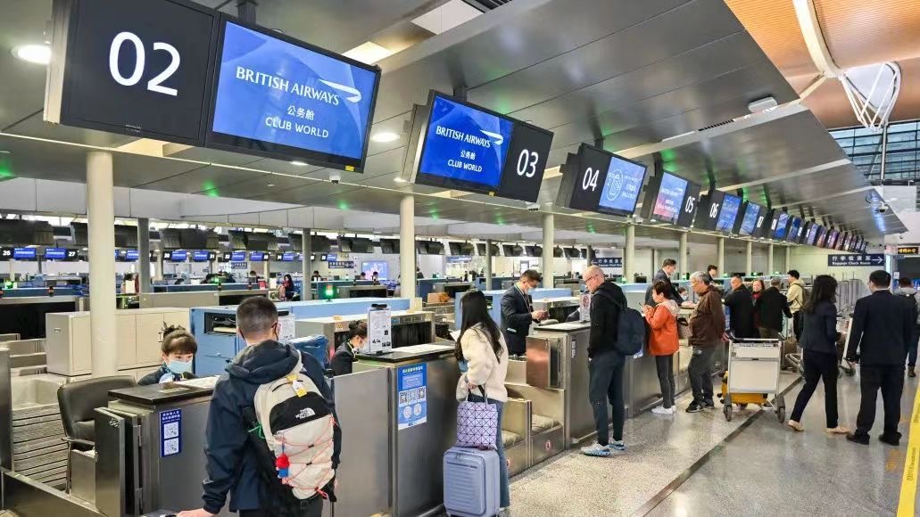 旅客在柜台办理登机手续.图片上海机场集团提供