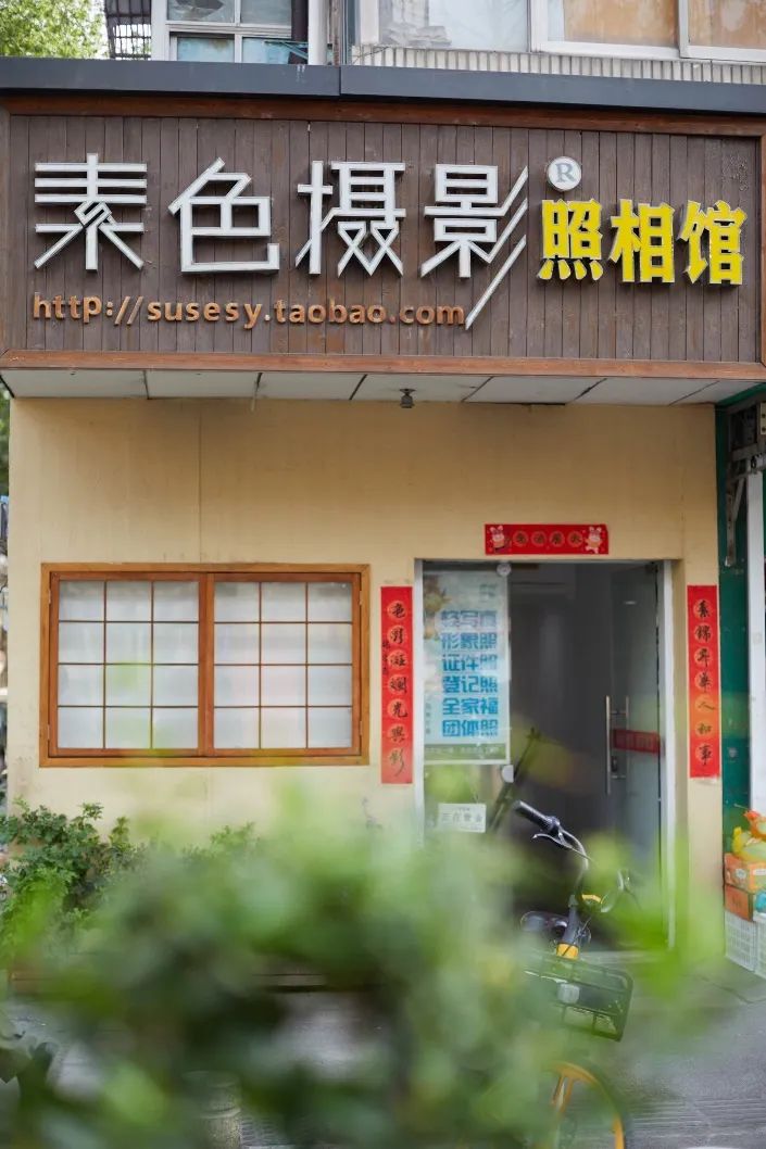 刘建的"素色"照相馆位于社区负一楼商铺,门头店招不大.