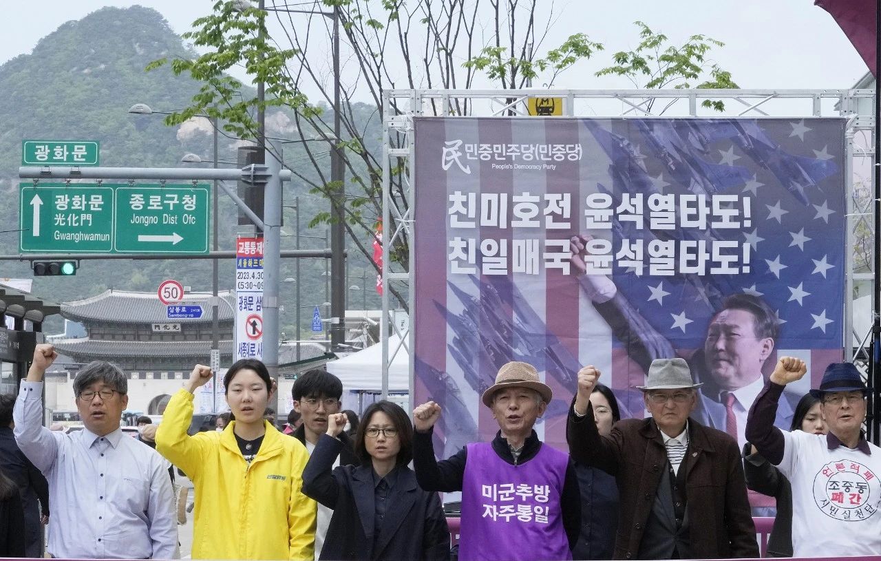  当地时间2023年4月21日，韩国首尔，抗议者举着印有韩国总统尹锡悦形象的横幅举行集会，谴责美韩对朝鲜的政策。图/视觉中国