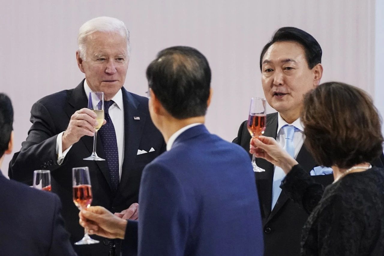  当地时间2022年5月21日，韩国首尔，在韩国国立博物馆举行的国宴上，美国总统拜登（左）准备和韩国总统尹锡悦（右二）向嘉宾敬酒。图/视觉中国