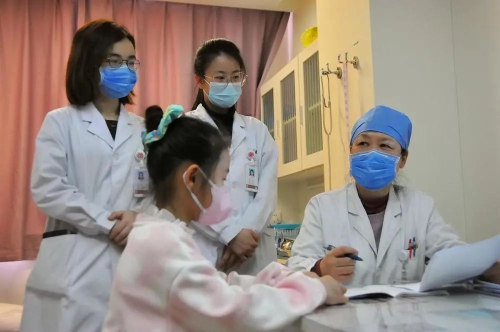 尹玲与团队成员在少儿妇科门诊一起接诊小患者.