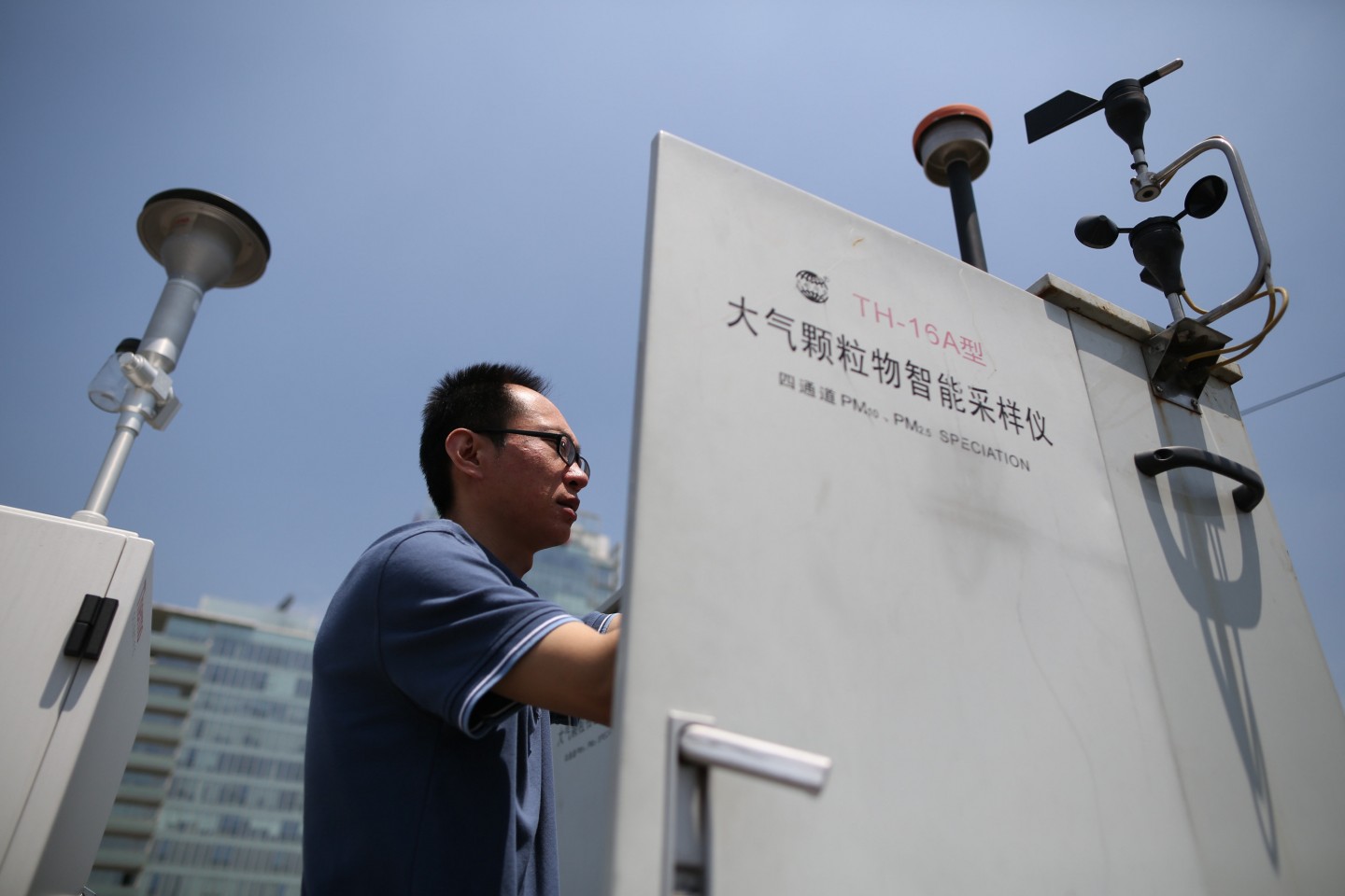 2014年6月9日，北京市环保局，工作人员在楼顶采集PM2.5大气样本。资料图片/侯少卿 摄
