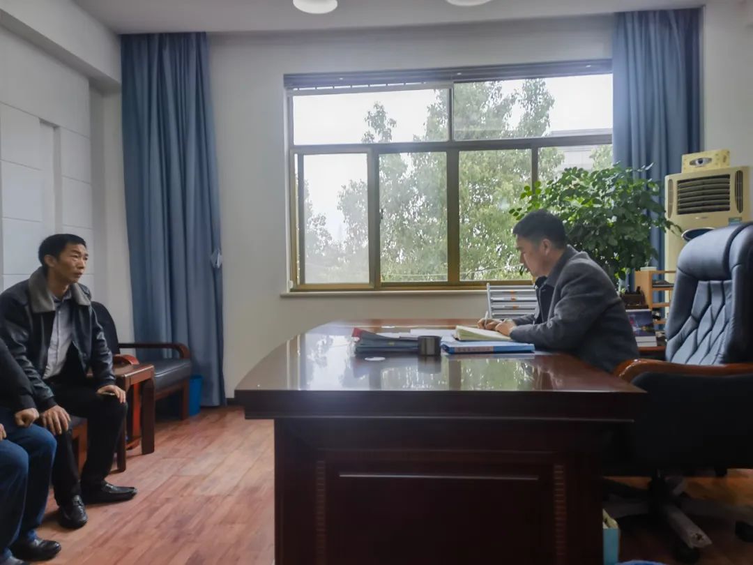 ▲3月22日上午,解伟在他的办公室和当地一家景区负责人讨论工作。新京报记者 李照 摄