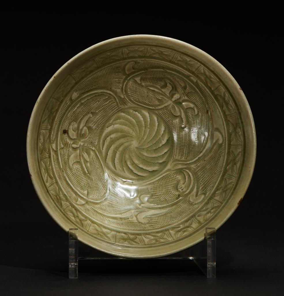 图为温州朔门古港遗址出土的"北宋龙泉窑青釉篦划莲花折扇纹瓷碗".