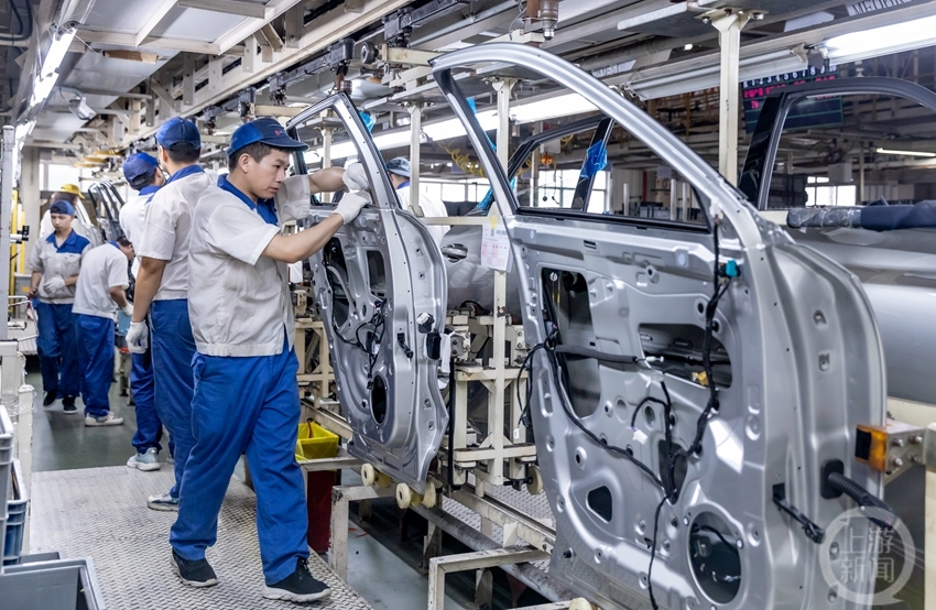 4月24日,重庆铃耀汽车有限公司二工厂总装车间,装配工人在整车生产线