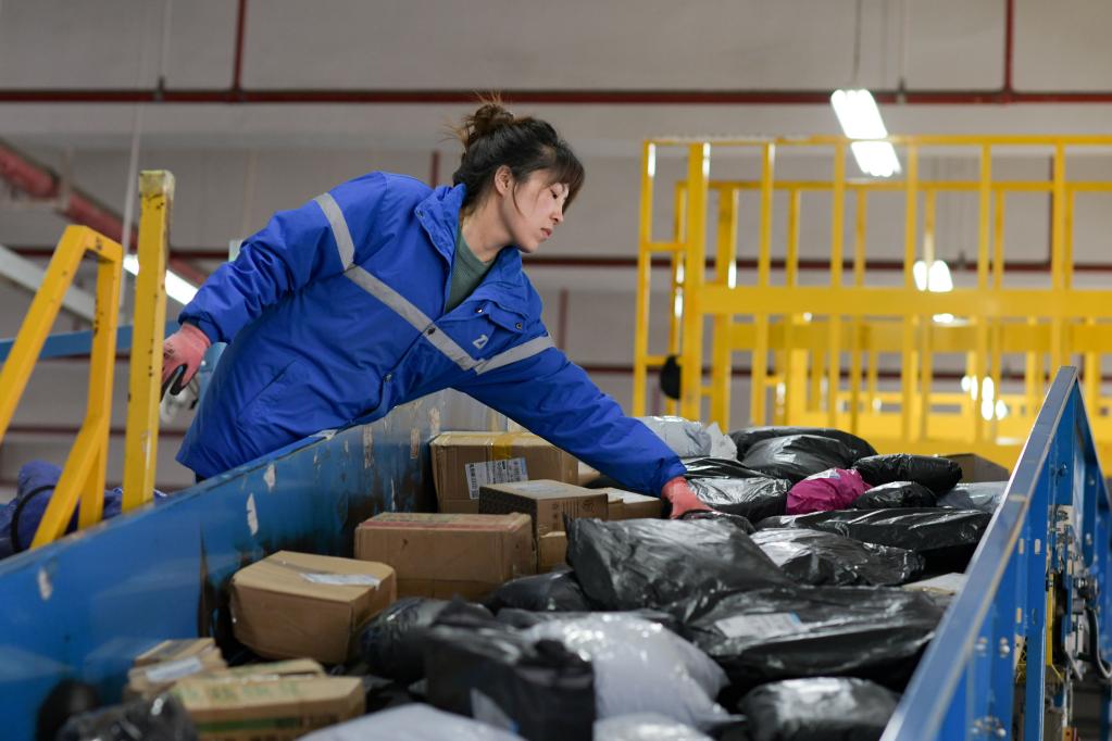 2月13日,一名工作人员在贵州快递物流园内分拣快递.