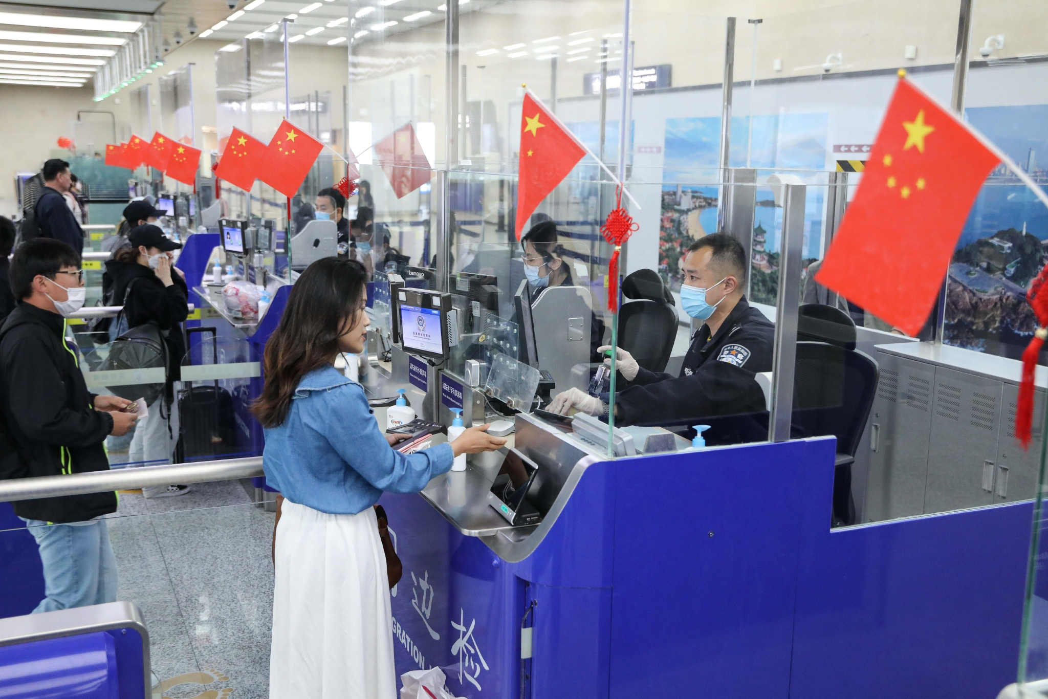 4月28日,山东出入境边防检查总站青岛机场边检站民警为旅客办理通关