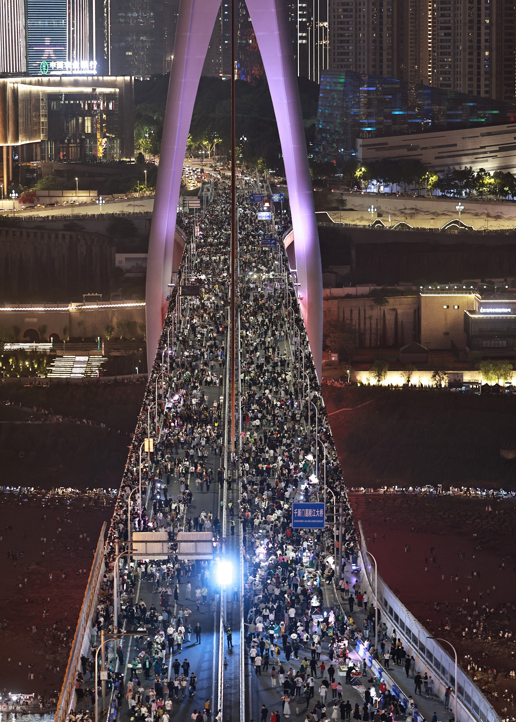 2023年4月29日，重庆洪崖洞封路封桥，千厮门大桥上挤满了密密麻麻的游客，方便游客打卡拍照。视觉中国 图