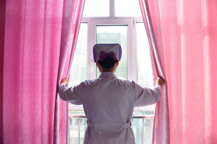 青海省海东市第一人民医院内科护士刘海婷在病房内为患者拉开窗帘