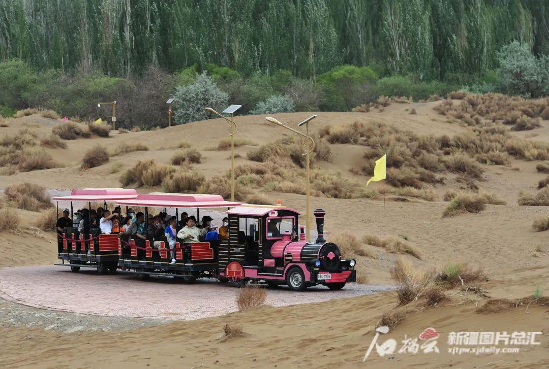 4月30日,游客在鄯善县库木塔格沙漠风景区乘坐观光车游览.刘健摄