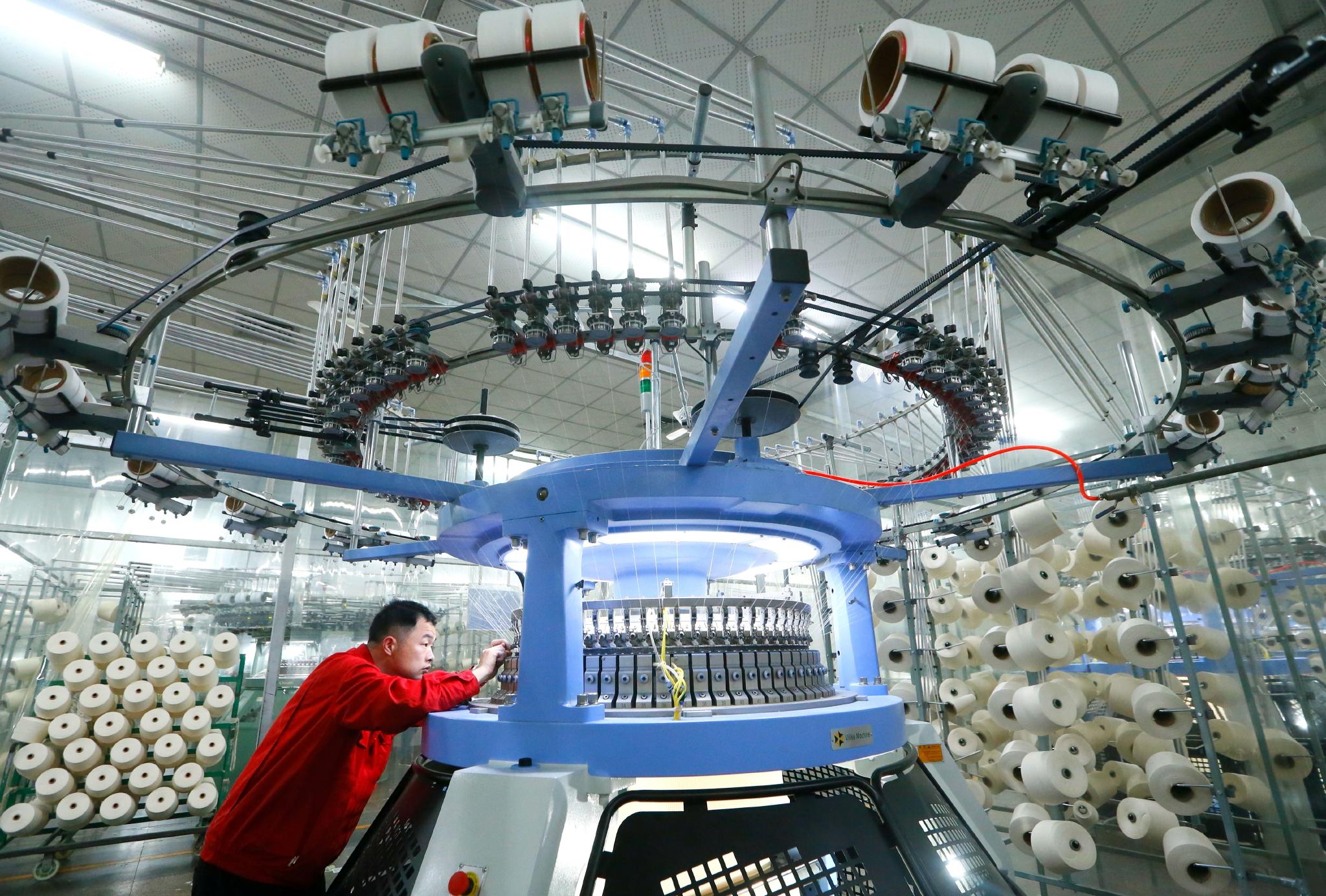 青岛市即墨区龙山街道一家纺织企业的工人在生产出口到海外市场的服装