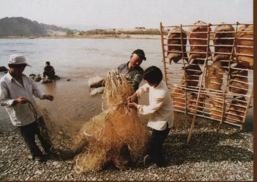 图为一家人准备乘坐羊皮筏子去黄河捕鱼。（图片来源：中国民族图片库）