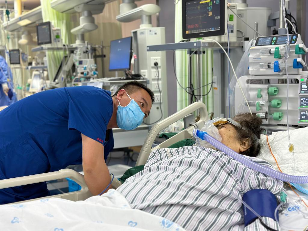 5月10日,在青海省人民医院重症加强护理病房(icu),韩进海(左)在帮