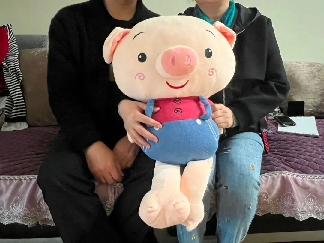 2021年11月3日，陈美霖的父母抱着孩子们生前最喜欢的玩偶。新京报记者 杨雪 摄