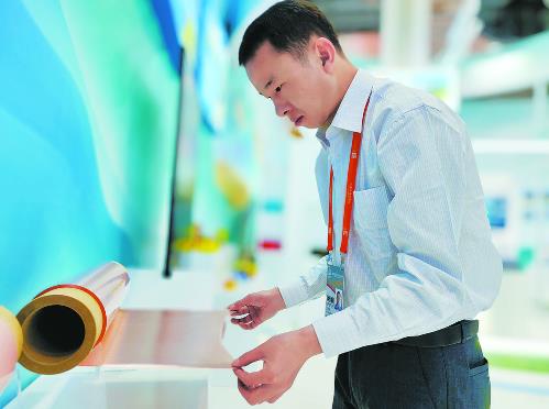 青海诺德工作人员向观众展示锂电铜箔产品.贾泓/摄