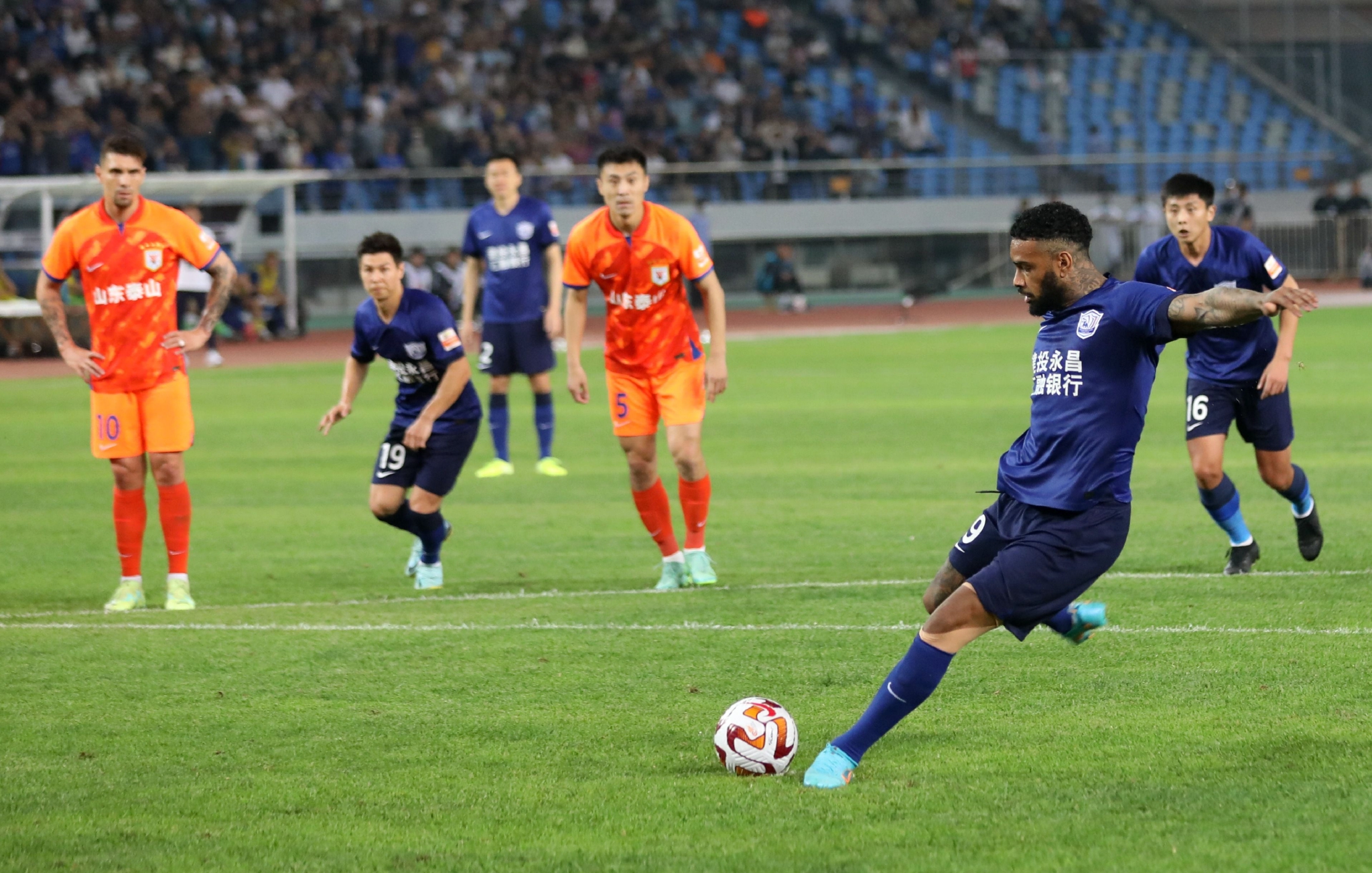 5月14日,沧州雄狮队球员洛卡迪亚(右二)在比赛中主罚点球得分.