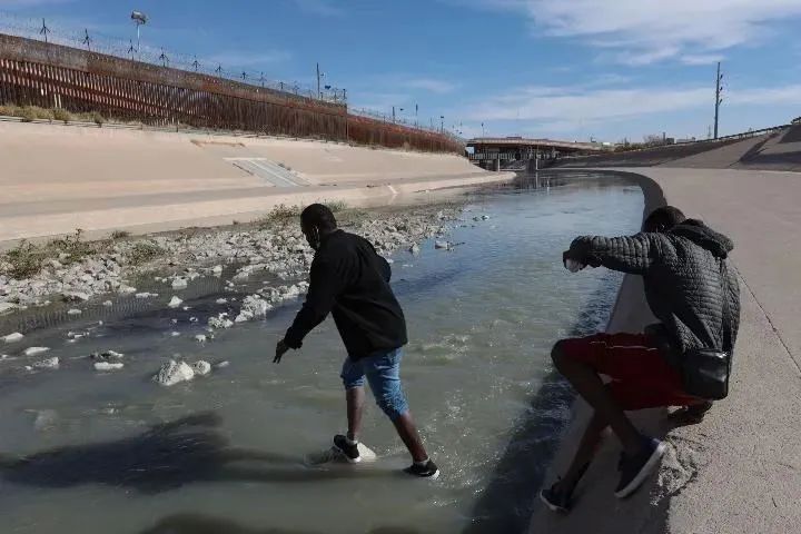2021年12月7日在墨西哥华雷斯城拍摄的照片显示，移民试图通过美墨边境的布拉沃河进入美国。新华社发（戴维·佩纳多摄）