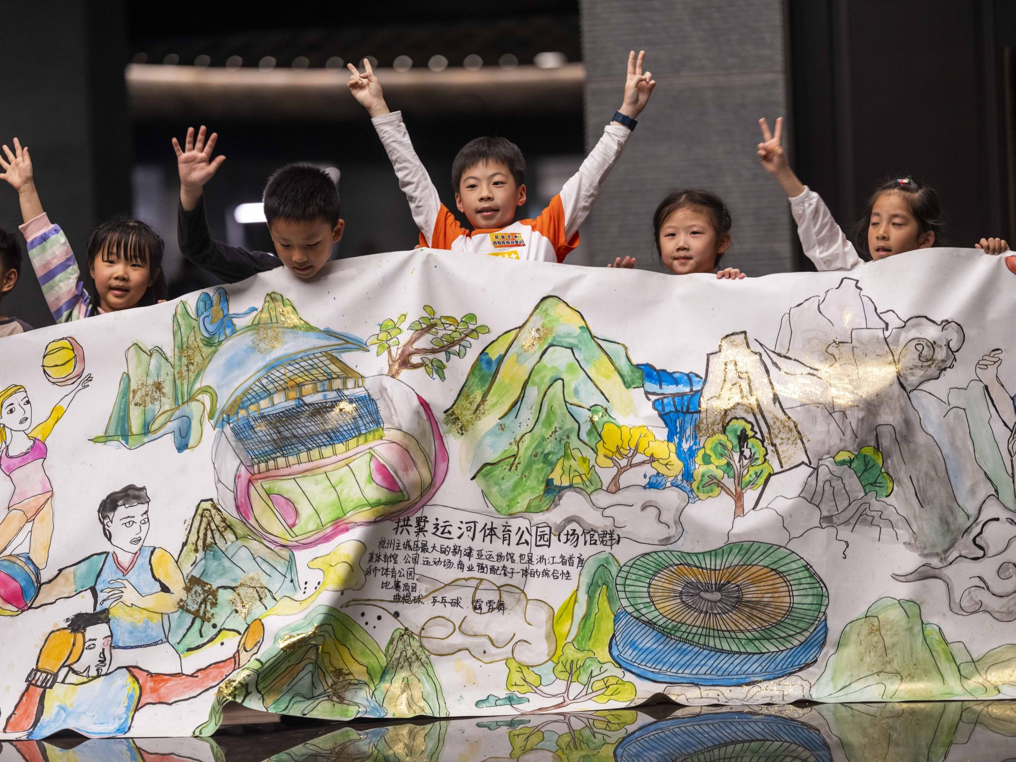 在大禹陵纪念馆,小朋友展示集体创作的"百米长卷迎亚运"绘画作品.