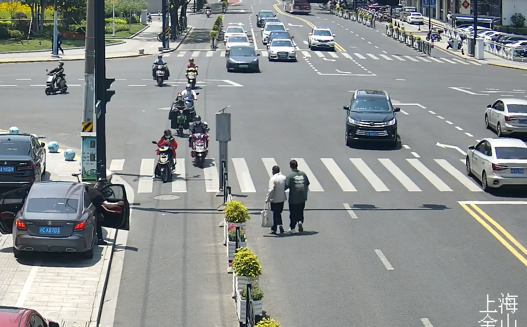 监控画面显示,罗晟上前搀扶老人,直到把老人送到路边安全的位置