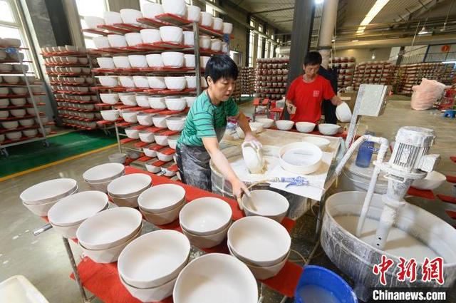 5月17日,山西省朔州市应县,陶瓷企业工人在车间上釉作业. 韦亮 摄
