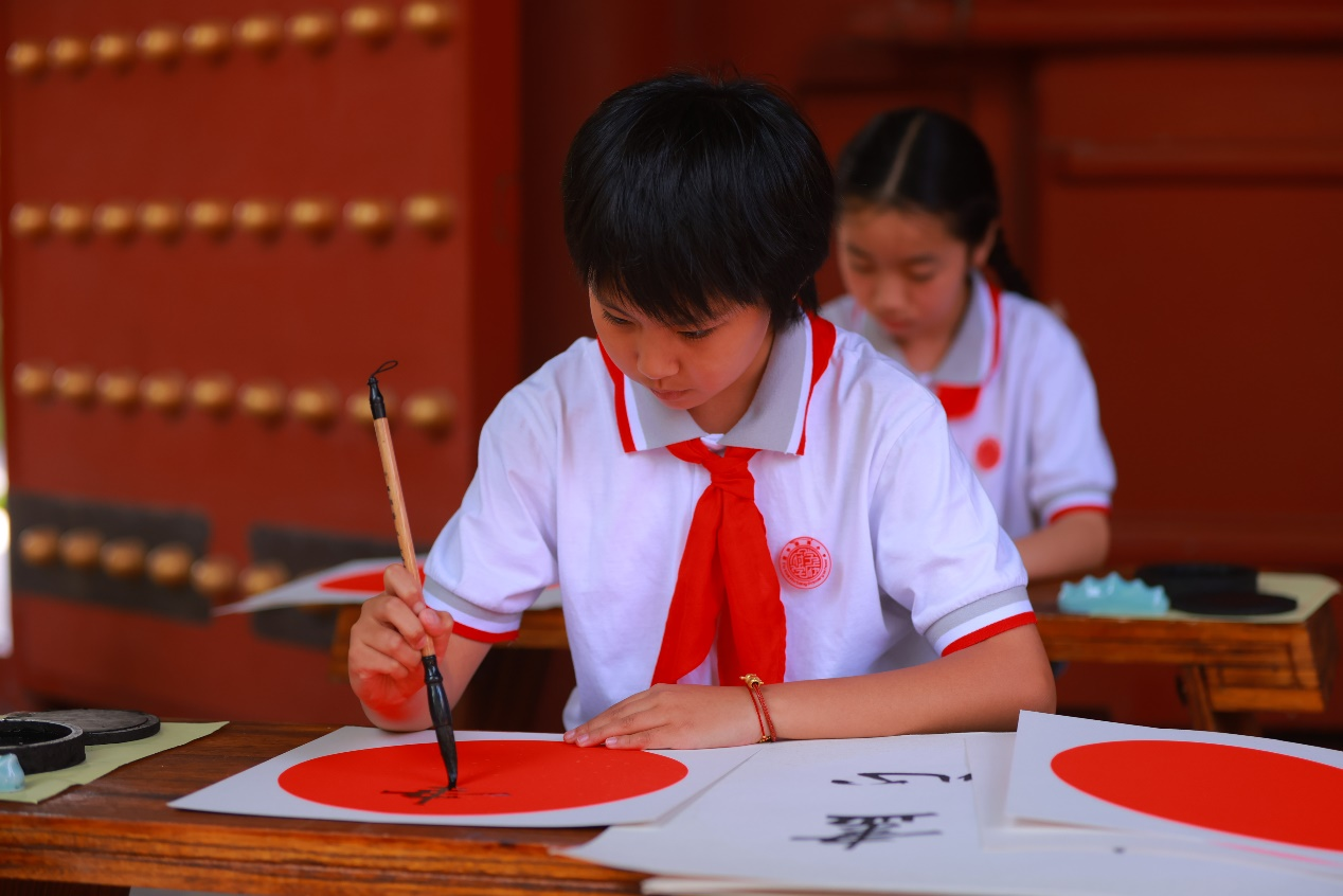 图为府学金帆书画院学生现场临摹书法,传拓石碑