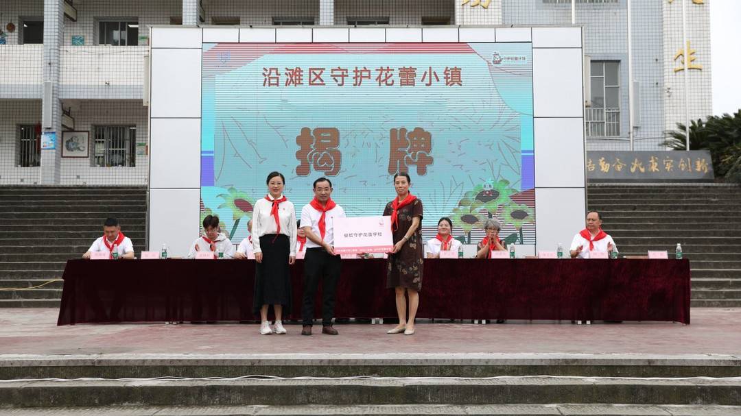 市扶贫"两会"向永安镇中心小学校授予"守护花蕾学校"牌匾;沿滩区教育