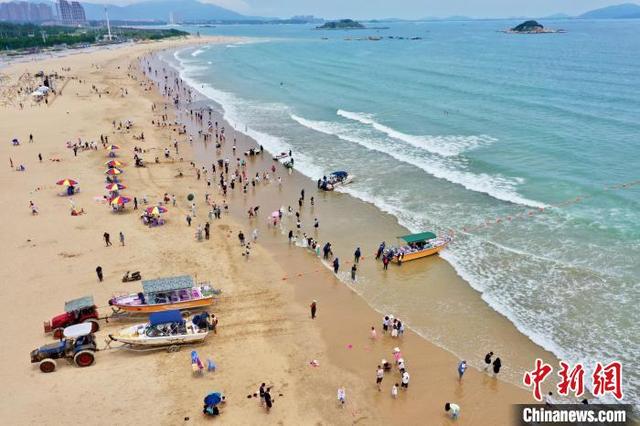 图为游客在龙王头海滩游玩. 王东明 摄