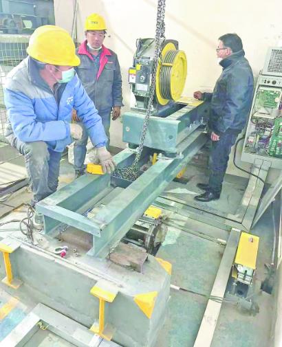 施工人员在电梯间安装主机.图片由城西区城乡建设局提供