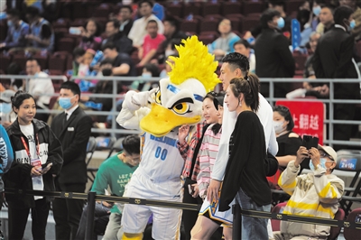 在首钢男篮CBA主场比赛日，霹雳鸭、翟晓川与现场球迷合影。新京报记者 王飞 摄