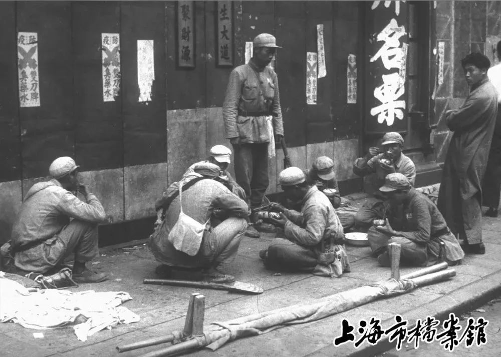解放军进入上海后，严守城市纪律，坐在马路边吃自带的干粮