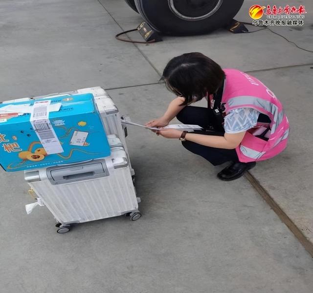 5月28日,乌鲁木齐国际机场工作人员正在为行李箱贴上行李直挂的标签.