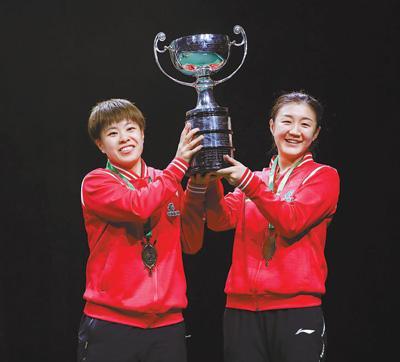 当地时间5月27日,女双冠军陈梦/王艺迪(左)在颁奖仪式上捧起奖杯.