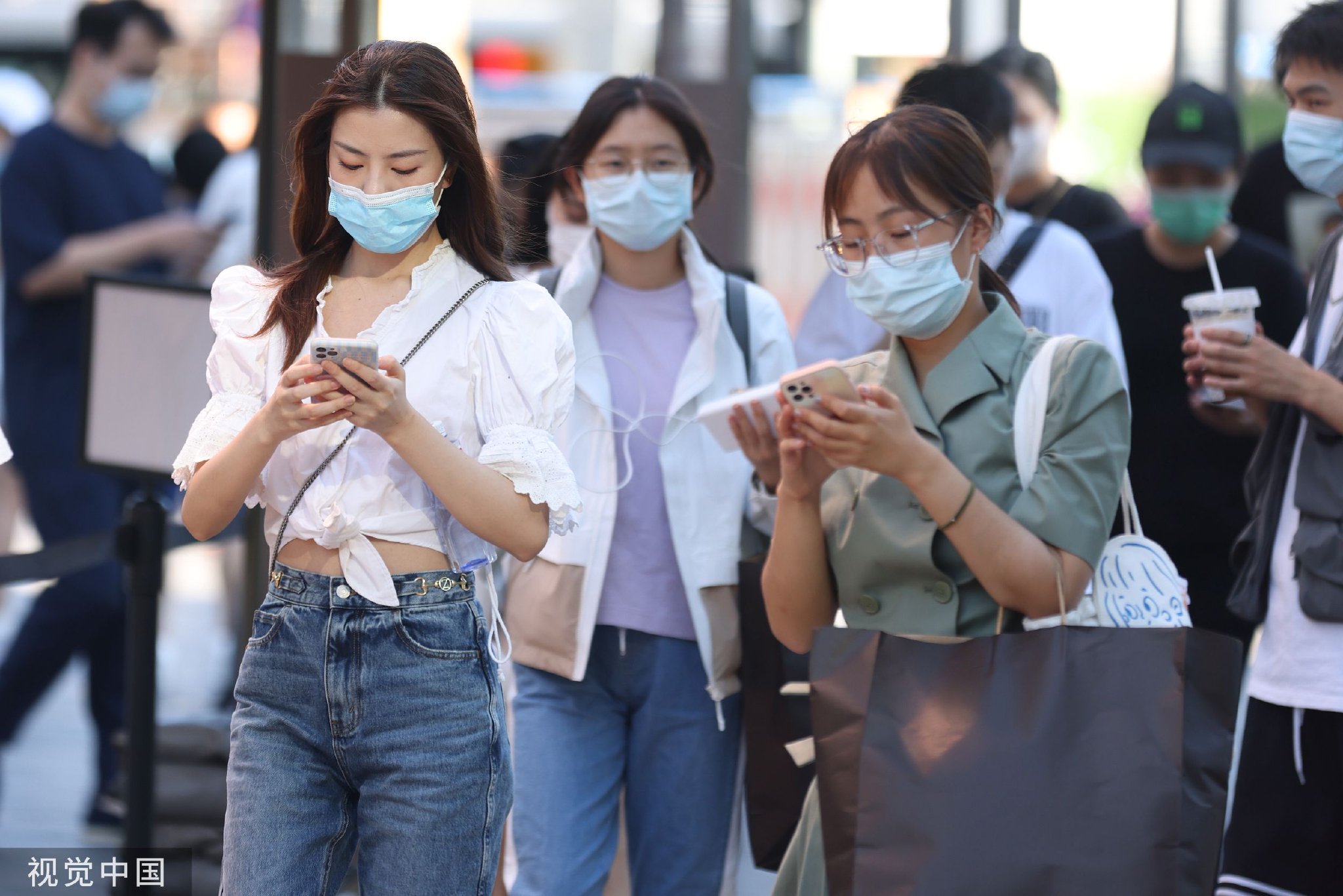 2021年8月27日,北京,市民在街头浏览手机.中新社记者 蒋启明 摄