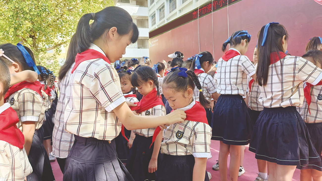 &nbsp;&nbsp;&nbsp;&nbsp;▲南宁市澳华小学老队员为新队员佩戴红领巾