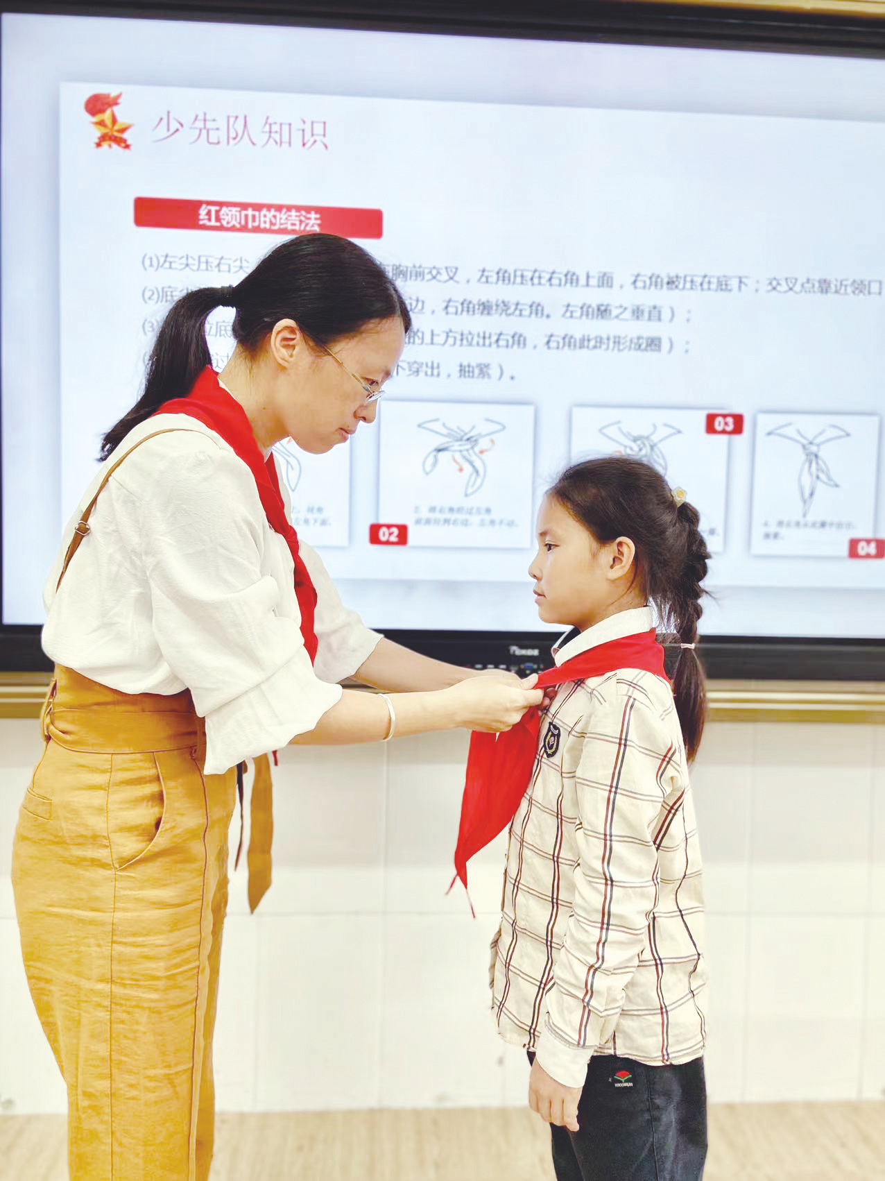 &nbsp;&nbsp;▲南宁市江南区邕津小学大队辅导员传授红领巾的正确佩戴