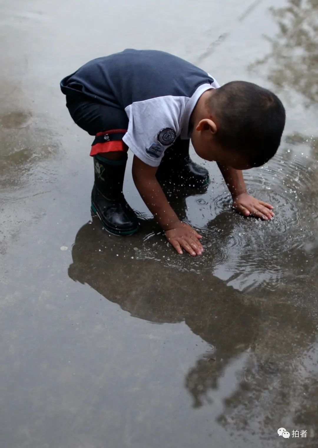 2009年9月4日,青云店,一场大雨过后,一个小朋友穿着雨鞋,双手触摸地