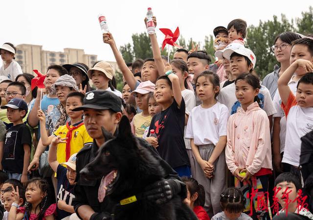 6月1日下午，北京市公安局警犬基地，前来参观的小朋友与警犬合影留念。中青报·中青网记者 李峥苨/摄