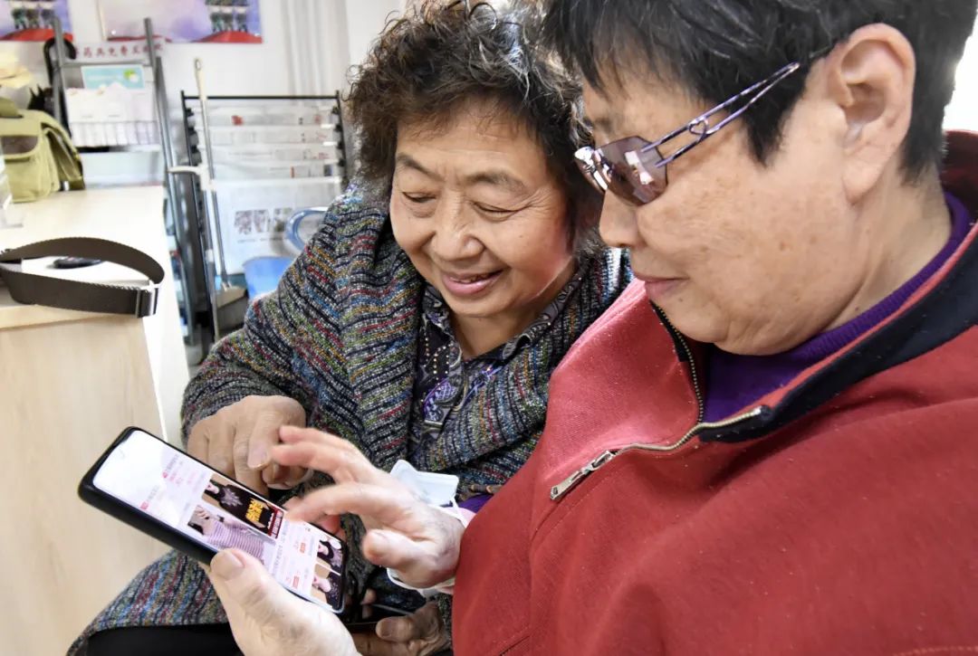 11月12日,北京市丰台区东高地街道万源南里社区的两位老人使用手机