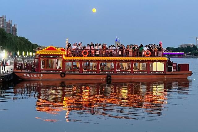 夜游大运河,市民在游船上追云赏月. 刘震/摄