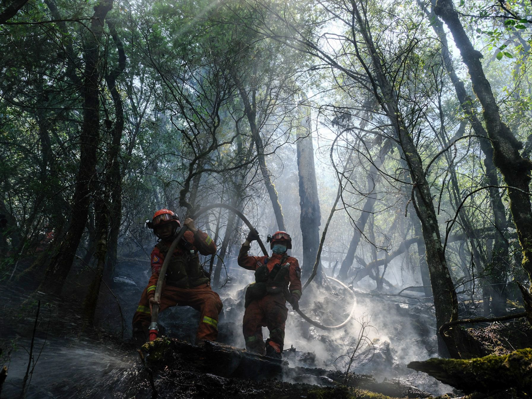 6月1日下午,四川凉山,成都森林消防大队消防员周维恒(左)正在木里火场