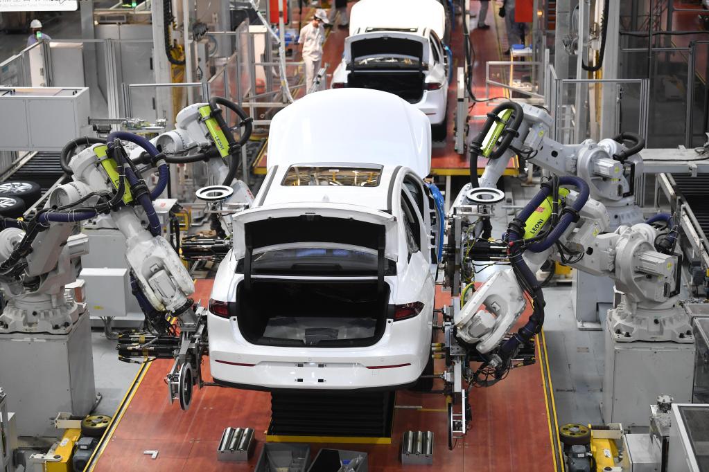 　　2月24日，在广汽埃安新能源汽车股份有限公司总装生产线，机器人手臂在安装汽车轮胎。新华社记者邓华 摄