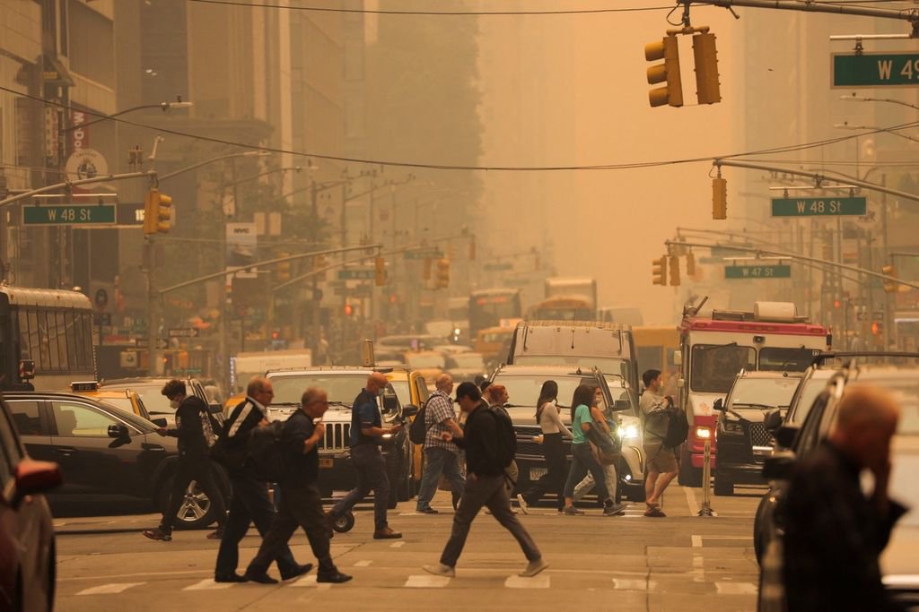 当地时间2023年6月7日，美国纽约，人们行走在被烟雾笼罩的街头。