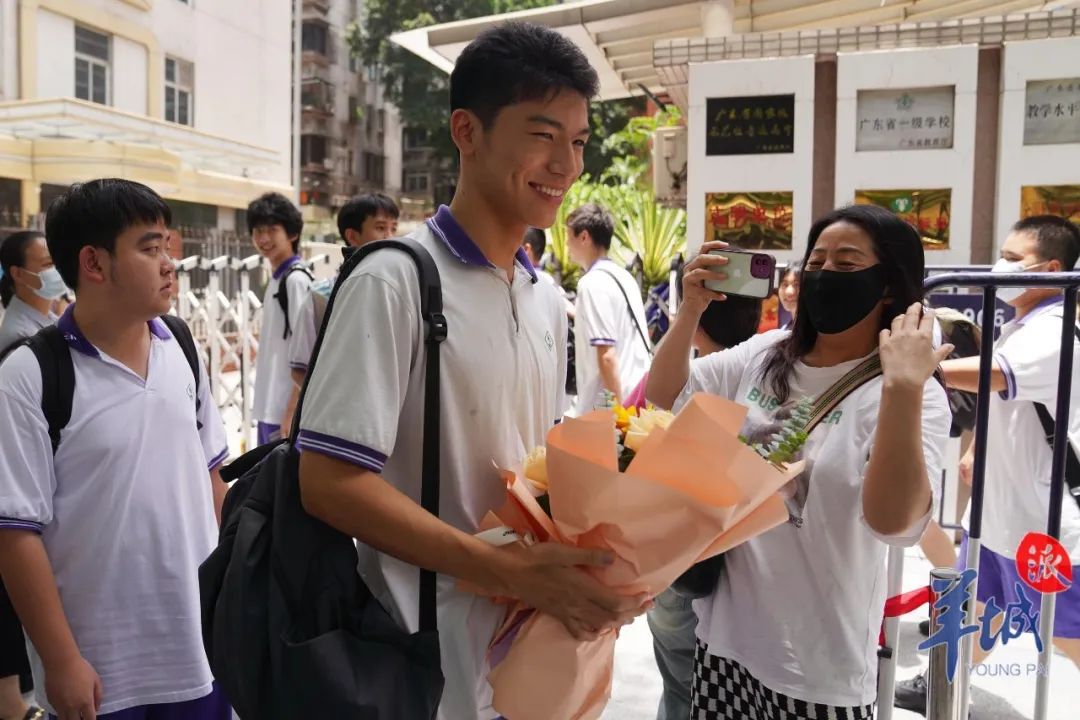 很多家长早早到场，手捧鲜花准备送给孩子，庆祝高考如愿