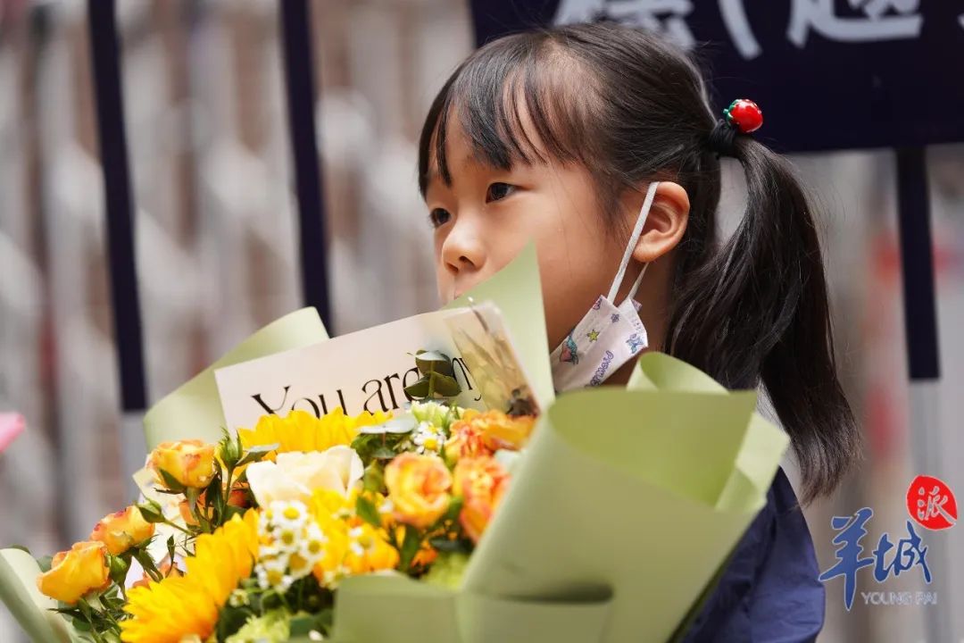 很多家长早早到场，手捧鲜花准备送给孩子，庆祝高考如愿