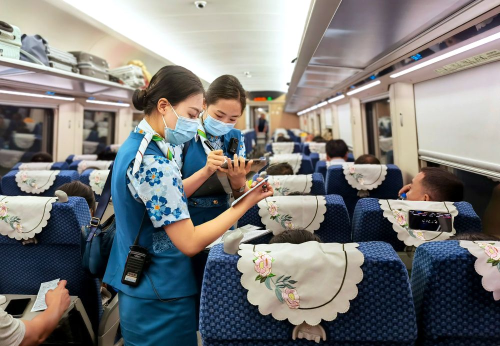 中老铁路国际旅客列车乘务员热情服务跨境旅客.欧婷蓉68摄