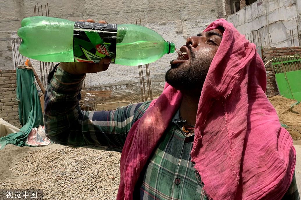 当地时间2023年6月13日,印度阿姆利则,一名工人在炎热的天气喝水解渴.