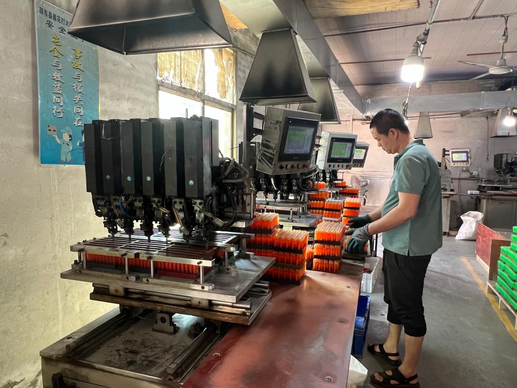 工人正在湖南邵东莲花打火机制造有限公司的充气车间工作.