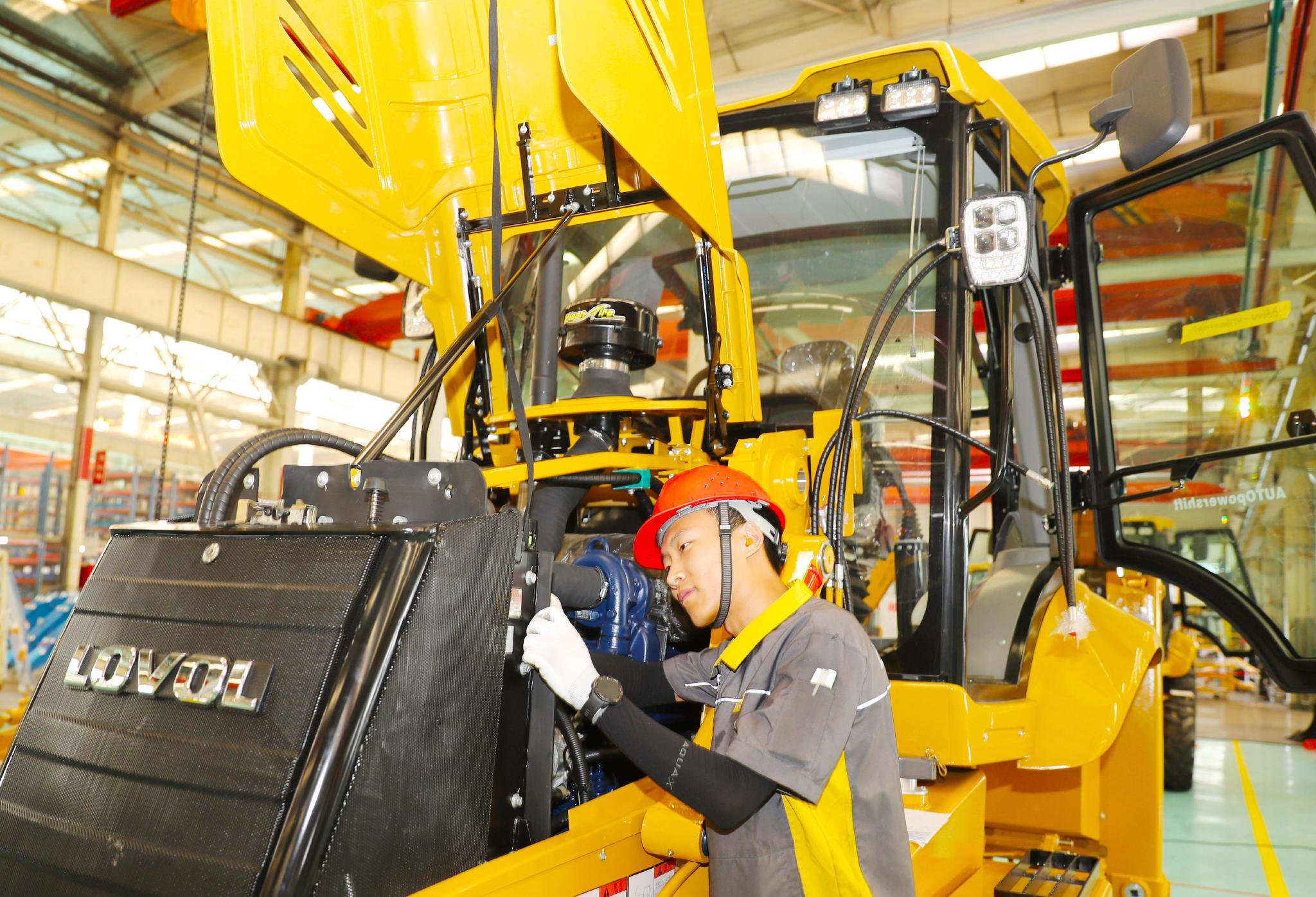 6月14日,在雷沃重工集团有限公司生产车间,工人在进行机械下线前的